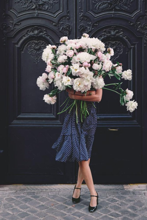 Hold The Faith is a photo of a girl in Paris in St Germain des Prés holding the biggest bunch of ancient white peonies and is part of a limited edition series named Young Girl in Bloom by photographer Carla Coulson celebrating women loving and believing in themselves and building their self esteem by trusting their intuition.