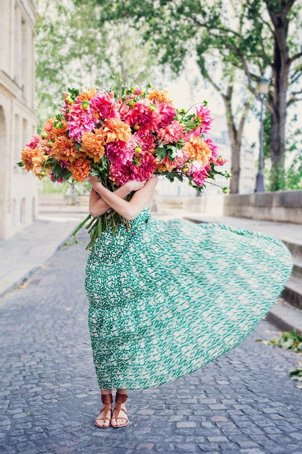 New Beginnings is a photo of a girl on the Ile St Louis in Paris with a big bunch of bright, joyous dahlias and is part of a limited edition series named Young Girl in Bloom by photographer Carla Coulson celebrating women loving and believing in themselves and building their self esteem by trusting their intuition.