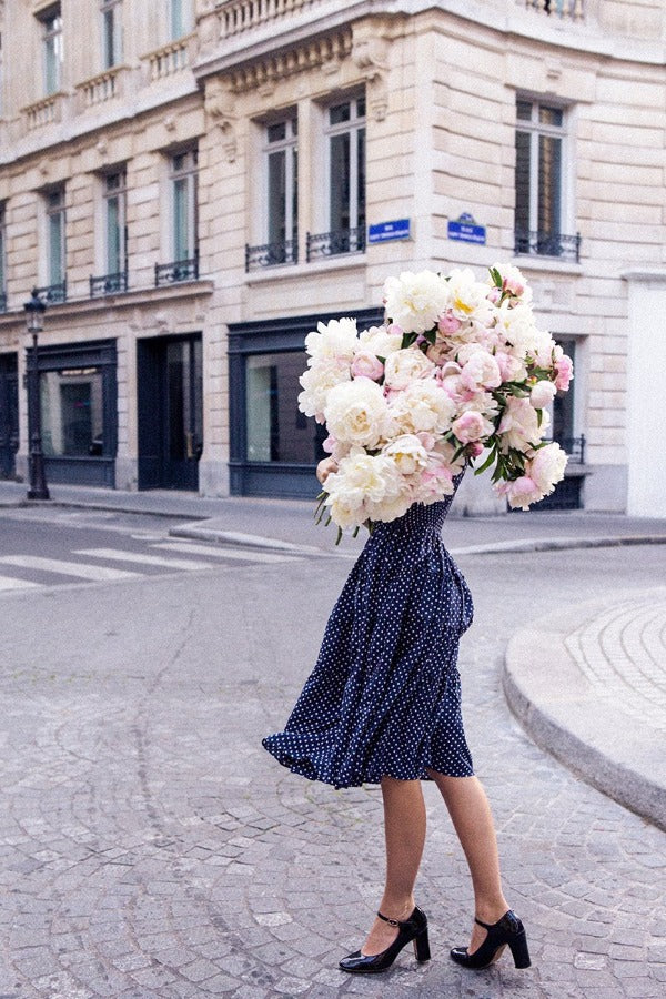 Listen To Your Heart is a photo of a girl in Paris in St Germain des Prés holding the biggest bunch of ancient white peonies and is part of a limited edition series named Young Girl in Bloom by photographer Carla Coulson celebrating women loving and believing in themselves and building their self esteem by trusting their intuition.